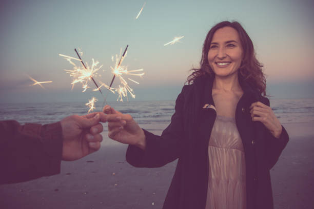 imagem de pov de duas mãos com sparklers - celebração do natal e do ano novo, conceito das férias de inverno - sparkler sparks new years eve human hand - fotografias e filmes do acervo