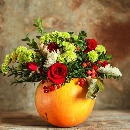 bouquet flowers in vase of pumpkin (roses, chrysanthemums, green branches, decoration), concept