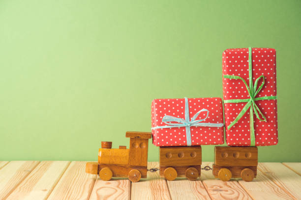 istock Christmas holiday celebration concept with gift boxes on toy train on wooden table. 1179176725
