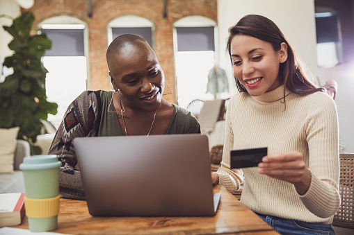 Women friends buying online using a credit card