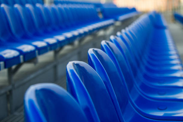 istock Blue plastic chairs in line for funs in sports stadium 1179180677