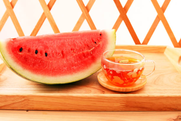 A cup of tea and fresh fruit on a wooden tray
