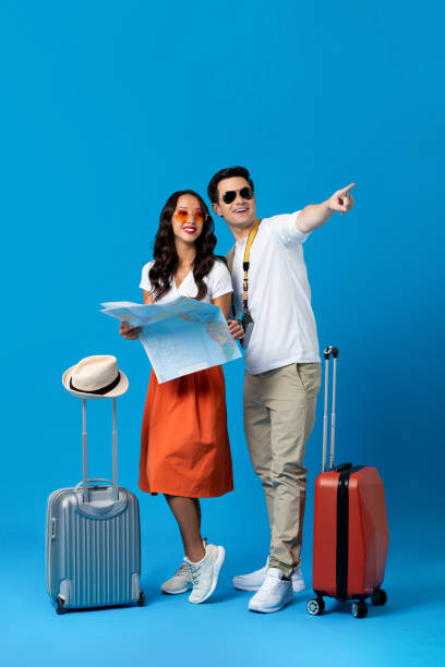 istock Tourist couple with baggage in blue studio background 1179183859