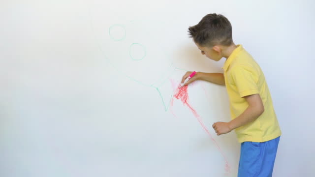 Boy drawing the rocket on white wall