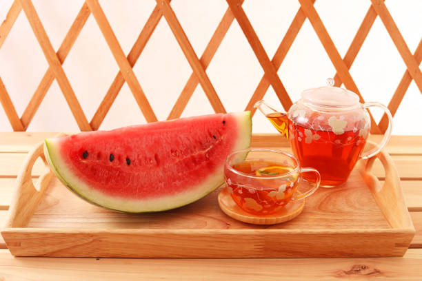 A cup of tea and fresh fruit on a wooden tray