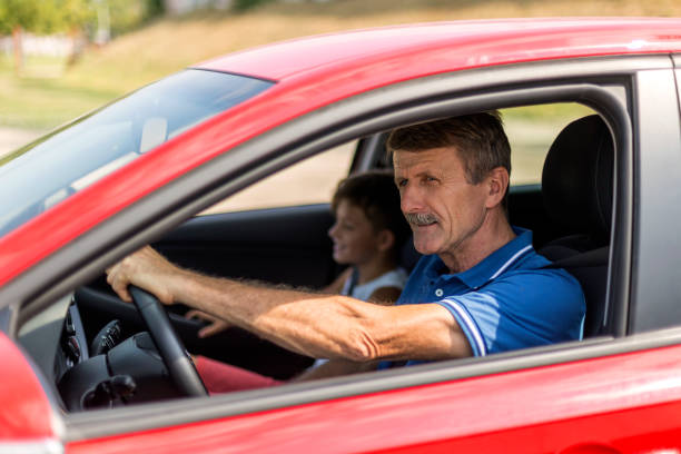 istock Senior man with a grandson in a car 1179185140