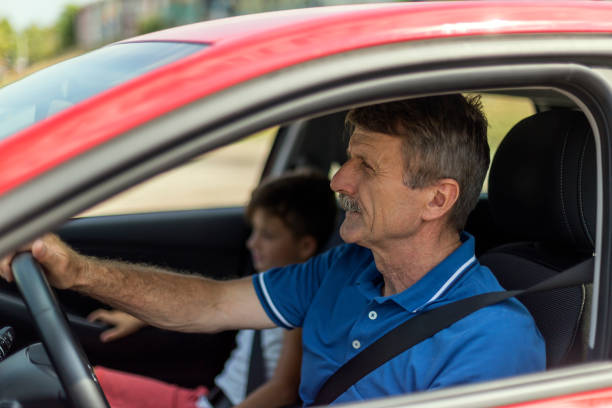 istock Man riding grandson in a car 1179185180