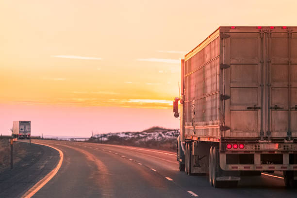 istock Semi-truck on highway traveling toward sunset 1179185227