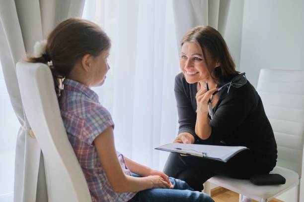 Woman elementary school teacher testing talking to girl Woman elementary school teacher testing talking to girl. Education, individual learning, child psychology mental health kids stock pictures, royalty-free photos & images