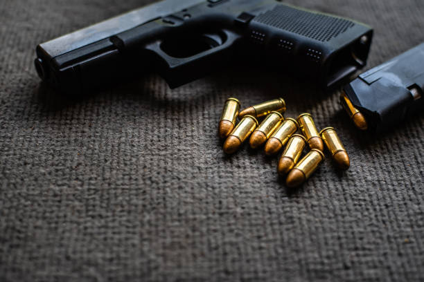 istock bullets and gun on black velvet desk 1179194942