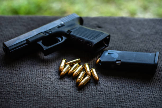 istock bullets and gun on black velvet desk 1179194957