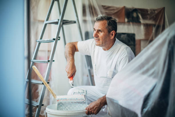 istock Senior painter painting living room 1179196323