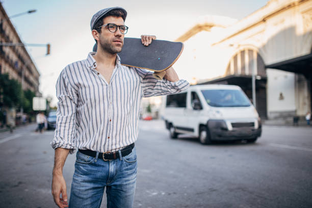 istock Modern guy with skateboard standing on the street 1179200026