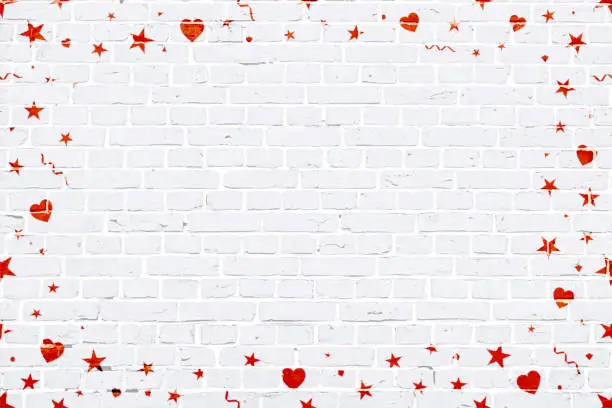 Vector illustration of Vector Illustration of a Christmas theme photo or picture frame in bright red coloured elements hearts , stars, swirls, twirls surrounding/ making a border of a grunge textured brick wall