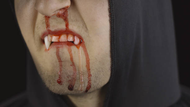 istock Man vampire Halloween makeup and costume. Guy with blood on his face 1179201484