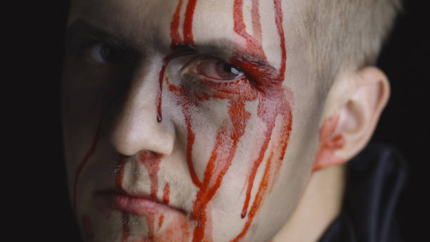 istock Halloween man portrait. Guy with dripping blood on his face. Scary makeup 1179201525