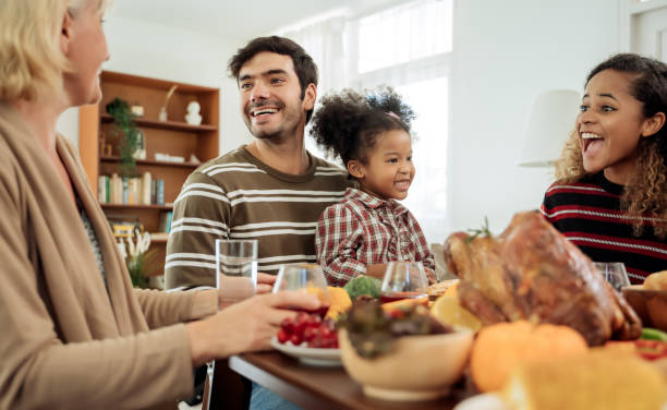 счастливая семья празднование благодарения ужин дома . концепция традиции празднования дня благодарения - telling time стоковые фото и изображения