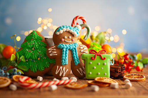 Christmas gingerbread cookies with Christmas decorations on wooden background. Traditional Christmas baking.