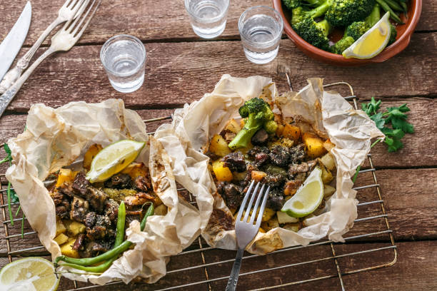 traditional greek kleftiko, an oven-baked lamb stew with potato, olive oil, onion, carrot, garlic and herbs, served with lemon and ouzo. - central greece imagens e fotografias de stock