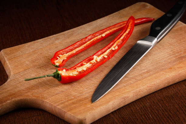 Chili pepper and knife on board