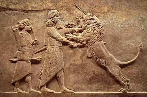 Assyrian wall relief, detail of panorama with royal lion hunt. Old carving from the Middle East history. Remains of culture of Mesopotamia ancient civilization. Amazing Babylonian and Sumerian art.