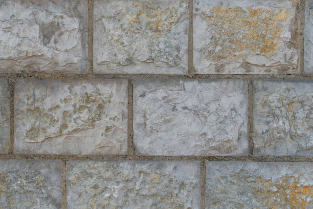 istock Wall of gray pale blocks with cement joints and cracks close up 1179232651