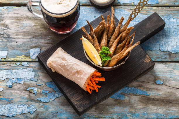 Beer snack deep fried small fishes with carrots sticks stock photo