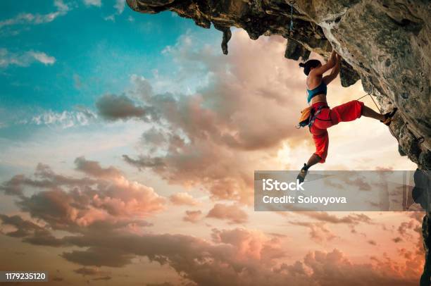 Atletische Vrouw Klimmen Op Overhangende Klif Rots Met Zonsondergang Hemel Achtergrond Stockfoto en meer beelden van Klimsport