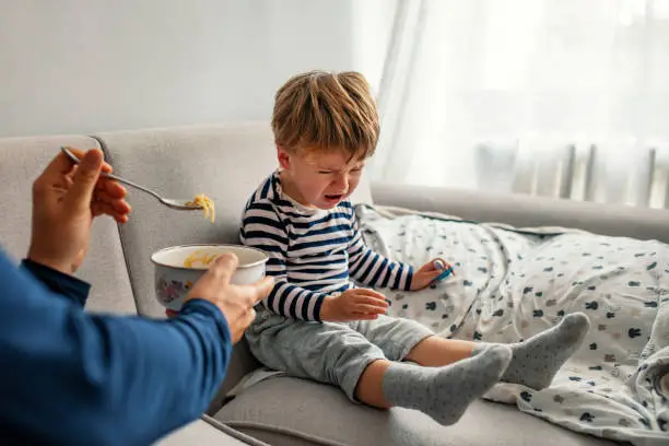 Photo of Little baby boy crying and screaming during eating