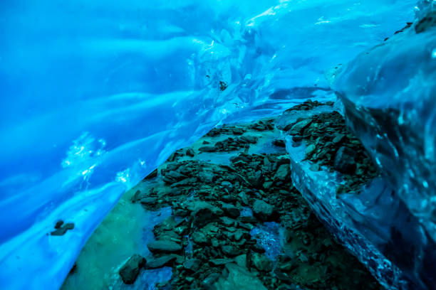 Deep in the Canadian wilderness, and below the Salmon Glacier, a river carries dirt and rock into the glacier and cuts a narrow canyon through the ice, creating an ice cave.