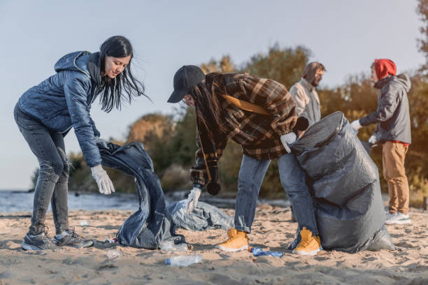 istock Volunteer concept. Young people gathering garbage outdoors 1179252622