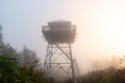 Foggy sunrise at the Rich Mountain fire lookout tower on the Appalachian Trail, near Hot Springs, North Carolina.