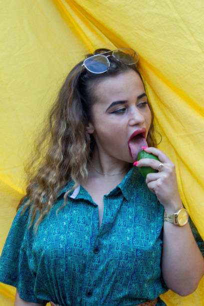 młoda kobieta gryzie cytrynę. kwas i gorzki. - lemon sour taste biting eating zdjęcia i obrazy z banku zdjęć