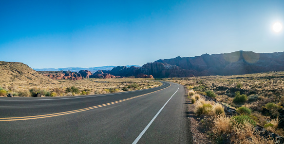 Two Way Road With Curve to the Left at Sunset With Flare showing on Right