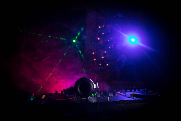 mezclador dj con auriculares sobre fondo oscuro de discoteca con el árbol de navidad de nochevieja. vista de cerca de los elementos de año nuevo en una mesa dj. concepto de fiesta navideña. - luces estroboscópicas fotografías e imágenes de stock