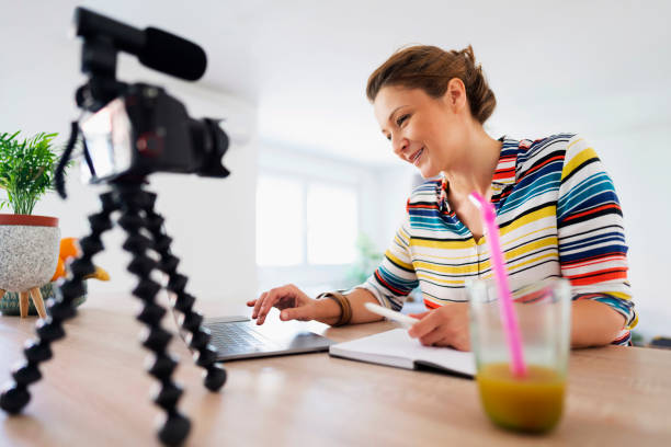 Creating videos to promote her home-based business Beautiful caucasian woman recording her video tutorial at home. image based social media stock pictures, royalty-free photos & images