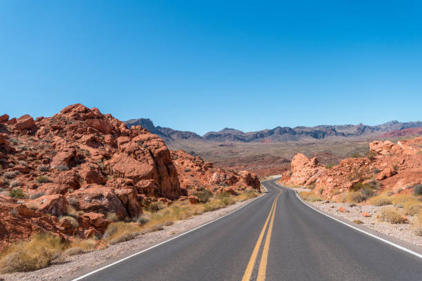 istock Two Way Highway Crossing Large Red Sandstones Rocks with Clear Skies 1179266904