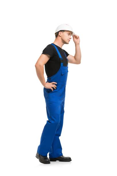 istock Man in blue work overolls and helmet isolated view 1179284233