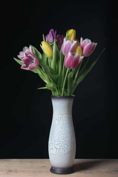 istock tulips in vase with cracked texture 1179296442