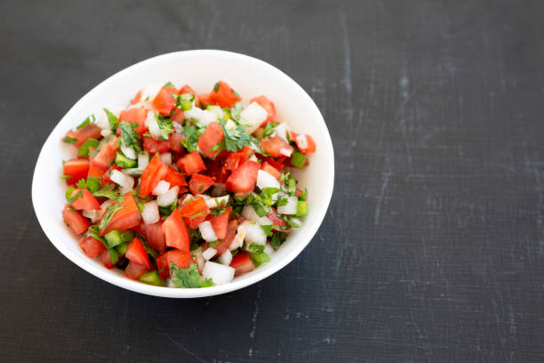 istock Pico de Gallo in a white bowl on a black background, low angle view. Copy space. 1179301382