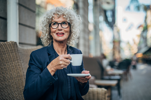 Beautiful senior woman drinking a hot drink in coffee shop