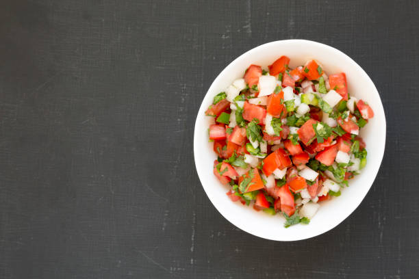 istock Top view, Pico de Gallo in a white bowl on a black surface. Overhead, from above, flat lay. Space for text. 1179303031