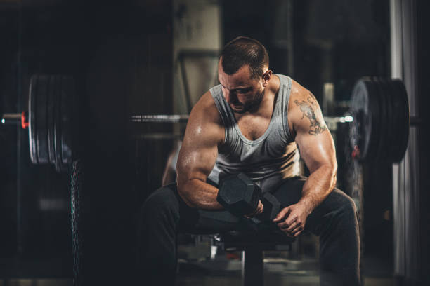 istock Muscular man doing exercises with dumbbells 1179303089
