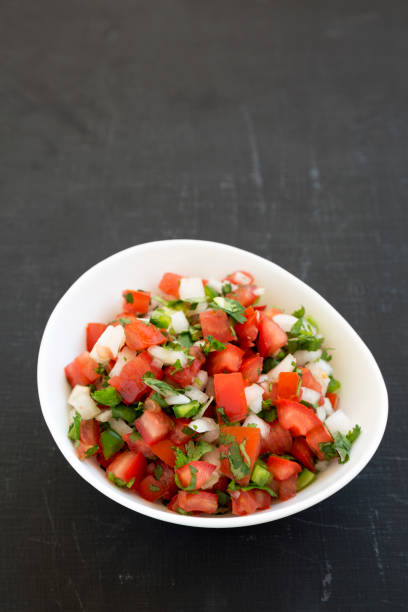 istock Pico de Gallo in a white bowl on a black background, low angle view. Copy space. 1179303131
