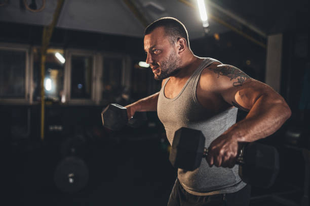 istock Muscular man doing exercises with dumbbells 1179303177