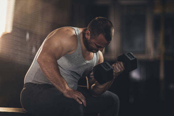 istock Muscular man doing exercises with dumbbells 1179303259