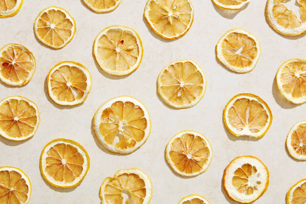 istock Sun dried lemon slices under hard sunlight with white stone background 1179304178