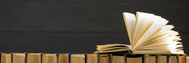 istock Open book, hardback books on wooden table. Back to school. Copy space 1179305929