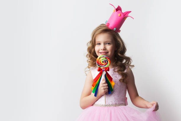 istock Girl in crown holding lollipop 1179307052
