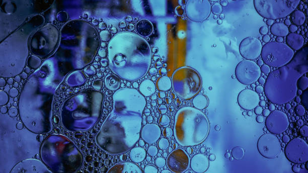 istock Oil drops on a water surface - Water bubbles abstract light illumination 1179309673